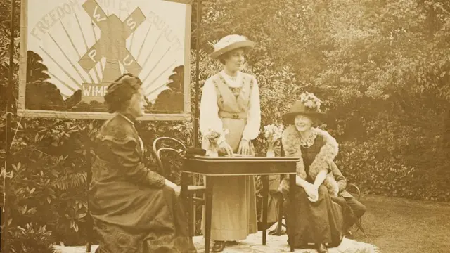 ییتس (در وسط) در حال سخنرانی در یک جلسه حق رأی در خانهاش در دورست هال