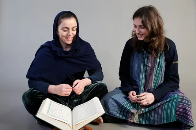 دو زن با حجاب و بی‌حجاب مقابل قرآن نشسته‌اند