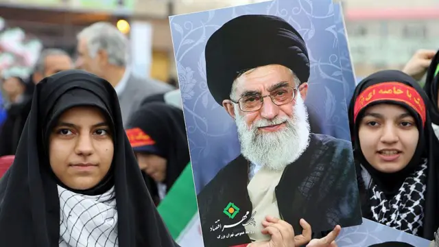 Иранские женщины несут плакаты с изображением Али Хаменеи во время митинга на площади Свободы в Тегеране по случаю годовщины исламской революции, 11 февраля 2015 года