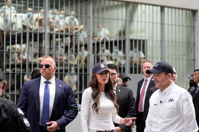 La secretaria de Seguridad Nacional de Estados Unidos, Kristi Noem, junto con el ministro de Justicia y Seguridad Pública de El Salvador, Gustavo Villatoro, durante un recorrido por el Centro de Confinamiento del Terrorismo (CECOT) mientras los prisioneros miran desde una celda, en Tecoluca, El Salvador, el 26 de marzo de 2025. (Foto de Alex Brandon / POOL / AFP) (Foto de ALEX BRANDON/POOL/AFP vía Getty Images)