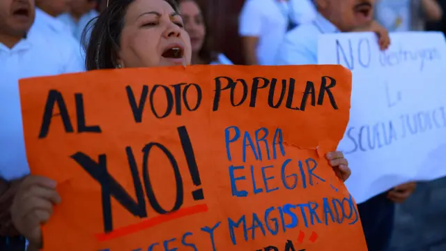 Mulher segura cartaz com mensagem contra a reforma