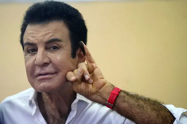 Salvador Nasralla muestra su meñique manchado de tinta después de haber votado.