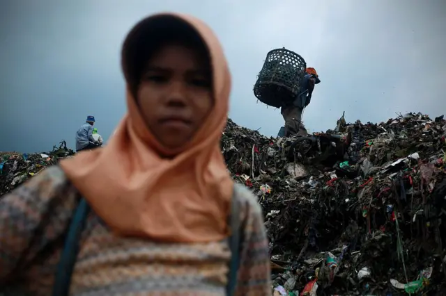 Seorang anak perempuan berdiri di atas tumpukan sampah tempat ia akan mengumpulkan plastik, di TPST Bantargebang.