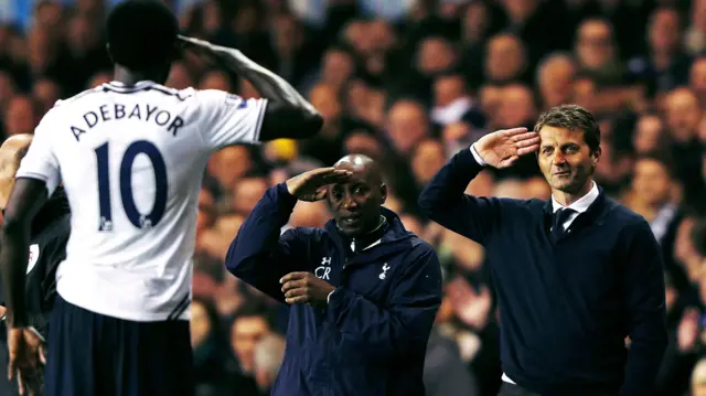 L'attaquant de Tottenham Emmanuel Adebayor, photographié de dos dans son maillot numéro 10, salue les entraîneurs Chris Ramsey et Tim Sherwood qui lui rendent la pareille.
