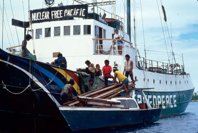 Tripulação do Rainbow Warrior ajudando pessoas de Rongelap a embarcar.