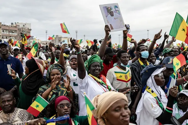 Des partisans du Premier ministre sénégalais Ousmane Sonko brandissent des drapeaux sénégalais lors d'un rassemblement à Dakar, le 8 novembre 2025.