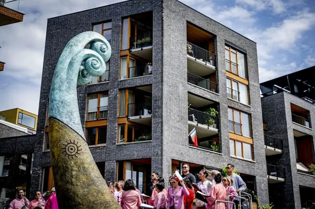 Orang-orang menunggu sebelum peresmian monumen nasional di Lloydkade untuk warga Maluku selama peringatan komunitas Maluku yang tiba di sana 75 tahun yang lalu, di Rotterdam pada 21 Juni 2026. Pada tahun 1946, pria-pria Maluku pertama datang ke Belanda untuk pelatihan dengan Angkatan Laut Kerajaan Belanda, setelah itu mereka bertugas aktif di Amsterdam, serta di Indonesia dan bagian lain Kerajaan Belanda.