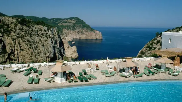 Turistas na piscina com o mar ao fundo