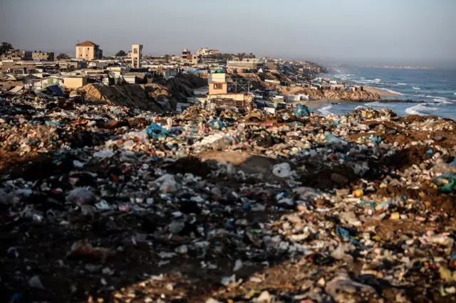 أكوام من القمامة بجوار الخيام التي تؤوي الفلسطينيين النازحين ​​في دير البلح في وسط قطاع غزة في 24 يونيو/حزيران 2024