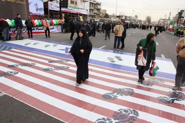 iranci prelaze preko velikih zastava sad i izraela postavljenih na ulici