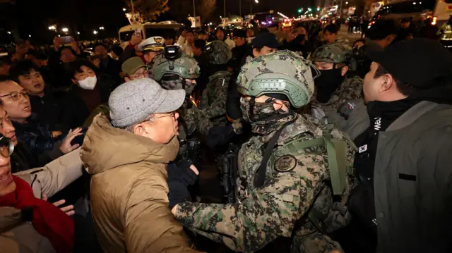 윤석열 대통령이 비상계엄령을 선포했던 4일 새벽 서울 여의도 국회 앞에 모인 시민들이 계엄군 진입을 막아서고 있다
