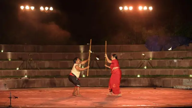 တုတ်ချောင်းကိုယ်စီကိုင်ထားတဲ့ အမျိုးသမီးတစ်ဦးနဲ့ အမျိုးသားတစ်ဦးတို့ အိန္ဒိယ ရှေးဟောင်းဓားသိုင်းပညာ လေ့ကျင့်နေကြပုံ