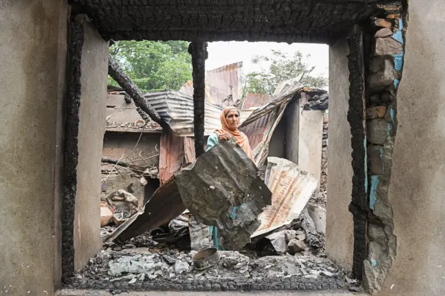 पाकिस्तानकडून झालेल्या हल्ल्यात उध्वस्त झालेल्या घराचा ढिगारा हटवताना महिला.