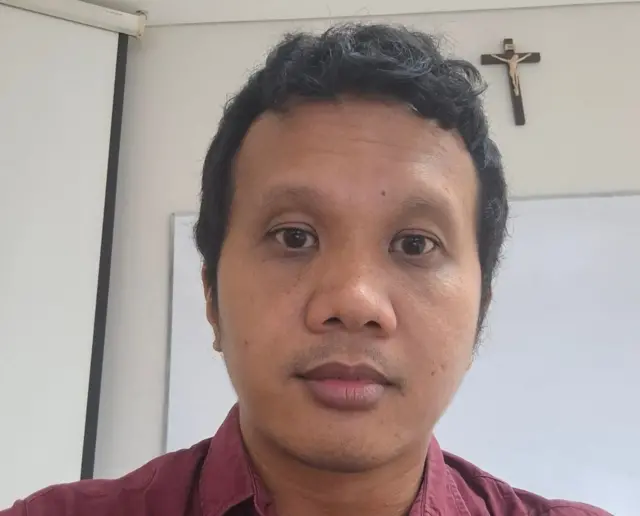 Ketua Satgas PPKPT, Datu Hendrawan sedang menghadap ke arah kamera dengan menggunakan baju kerah berwarna merah.