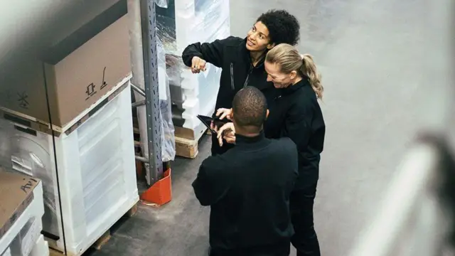 兩名女子與一名男子圍在一起在商討事情