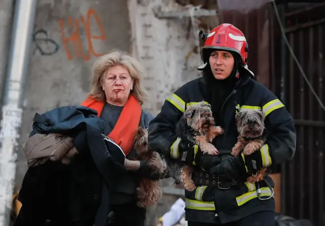 A Ukrainian rescuer helps an injured woman and her dogs after shelling in downtown Kyiv (Kiev), Ukraine, 10 October 2022.