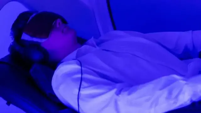 눈에 안대를 하고 파란 불빛을 쬐고 있는 남성