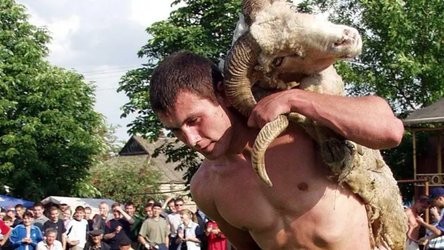 Учасник змагань з національної боротьби "Куреш" під час свята Панаїр несе приз - живого барана
