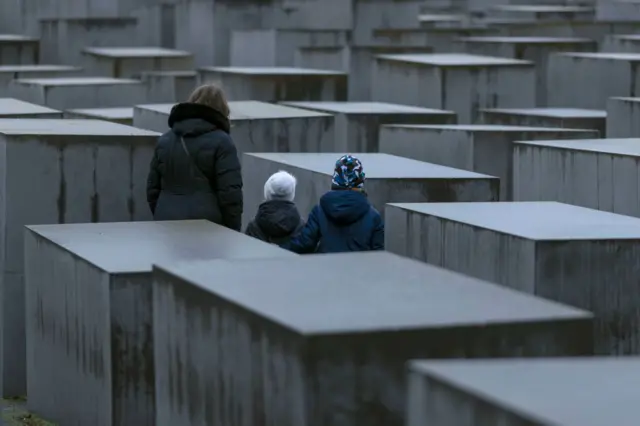 زوار يقفون عند النصب التذكاري للهولوكوست في اليوم العالمي لإحياء ذكرى المحرقة في 27 يناير 2023 في برلين، ألمانيا.