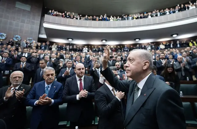 Cumhurbaşkanı Erdoğan partisinin grup toplantısında konuşmak üzere kürsüye yürürken dinleyicileri selamlıyor