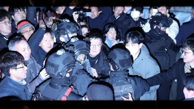 Miembros del ejército se abren paso entre la multitud frente a la Asamblea Nacional en Seúl en las primeras horas del 4 de diciembre después de que el presidente surcoreano, Yoon Suk-yeol, declarara la ley marcial.