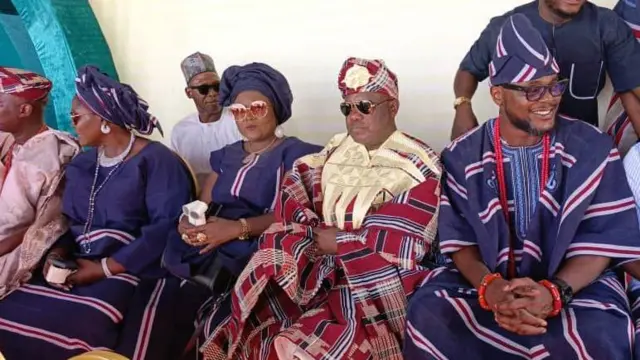 Àwọn èèyàn tó jókòó wọ onírúurú aṣọ oke 