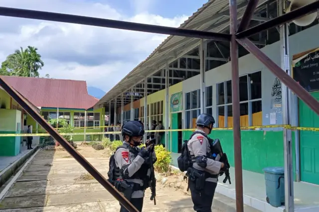 Personel Brimob Polda Sumatera Barat berjaga di lokasi ledakan yang diduga berasal dari bom rakitan di MAN 3 Kota Padang, Kelurahan Balai Gadang, Kecamatan Koto Tangah, Kota Padang, Selasa (14/07/2026). Polisi melakukan sterilisasi dan olah tempat kejadian perkara, sementara seorang siswa yang diduga membawa bom rakitan diamankan untuk menjalani pemeriksaan.
