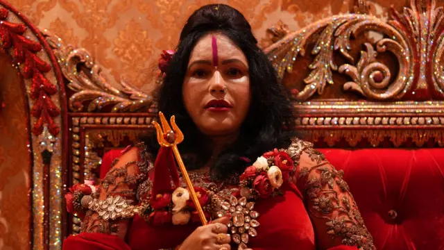 लाल कपड़े और हाथ में त्रिशूल पकड़े राधे मां