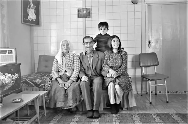 Siyah beyaz bir aile fotoğrafı. Bir baba, anne, çocukları ve yaşlı bir kadın yan yana bir divanın üzerinde poz veriyor. 