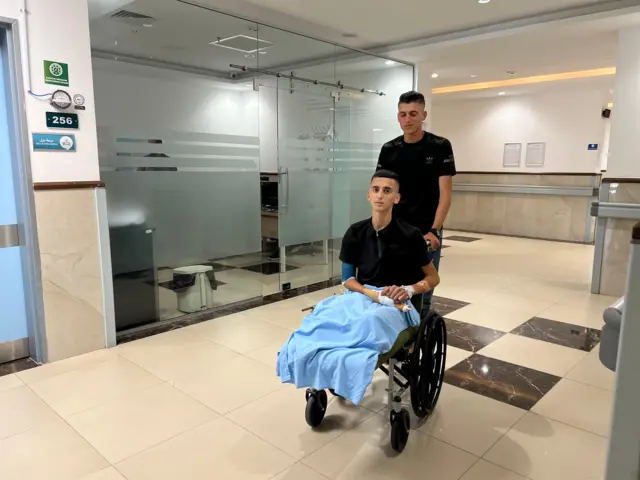 సోదరుడిని వీల్‌చెయిర్‌లో కూర్చోబెట్టుకుని నెట్టుకుని వెళుతున్న అబ్దుల్లా