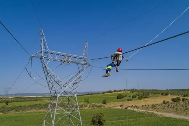2019 yılına ait arşiv fotoğrafında İzmir'deki bir yüksek gerilim hattında çalışan bir işçi görülüyor. İşçi, kabloların üzerinde çalışıyor. 