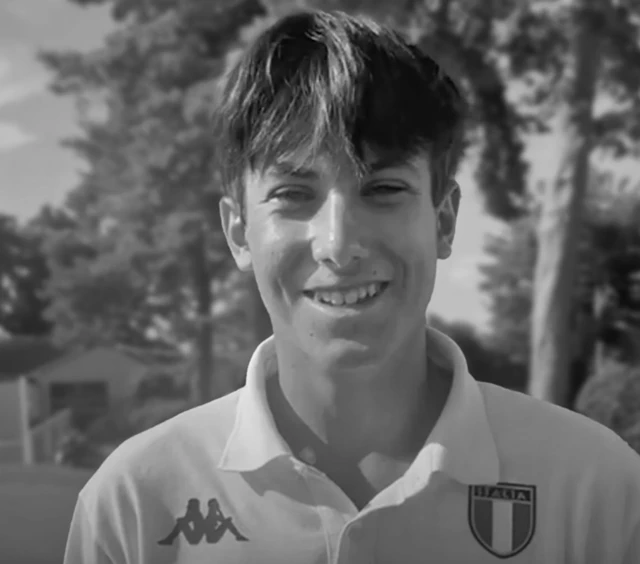 Siyah beyaz bir fotoğrafta İtalyan üniformalı bir çocuk kameraya gülüyor