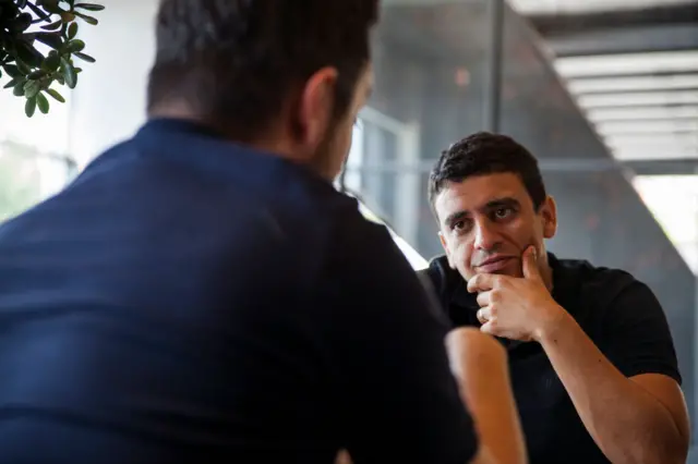 Karşısındaki kişiyi dinleyen bir adam