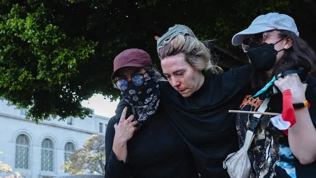 Los Angeles'ta yaralı bir protestocu, 8 Haziran 2025'te arkadaşlarının kolunda taşınıyor