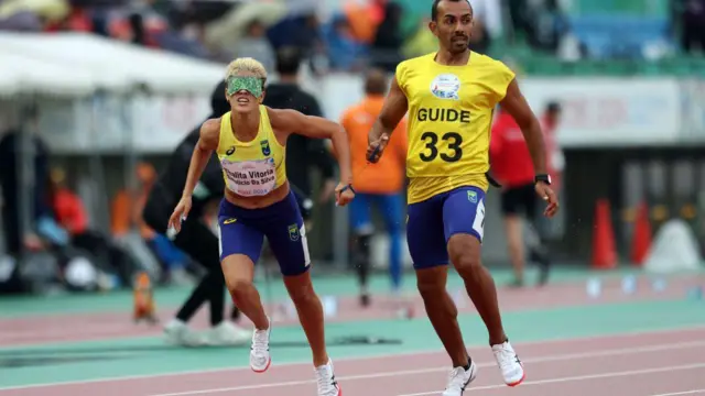 La medallista de plata Thalita Vitoria Simplicio da Silva, de Brasil, y su guía celebran tras competir en la final femenina de 400 m