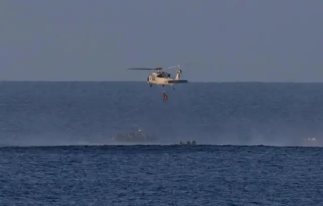 Dem carry Victor Glover onto a Navy helicopter