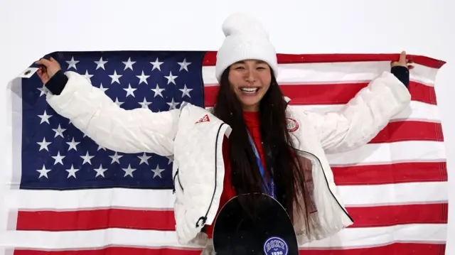 Американская сноубордистка Хлои Ким празднует завоевание серебряной медали во время церемонии награждения в соревнованиях по хафпайпу среди женщин