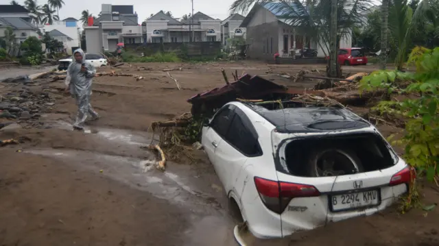 Warga melihat mobil yang tertimbun lumpur akibat banjir bandang di Lubuk Minturun, Padang, Sumatera Barat, Kamis (27/11/2025).