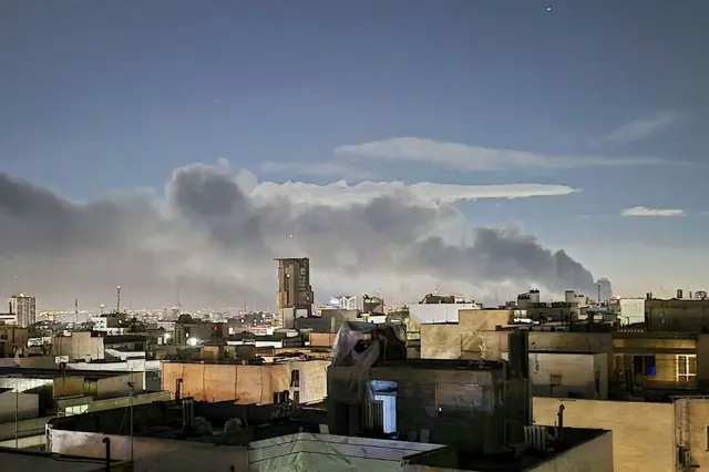 Una columna de humo asciende en un barrio de Irán