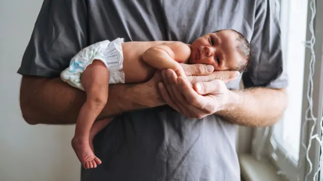 Pai com bebê nos braços