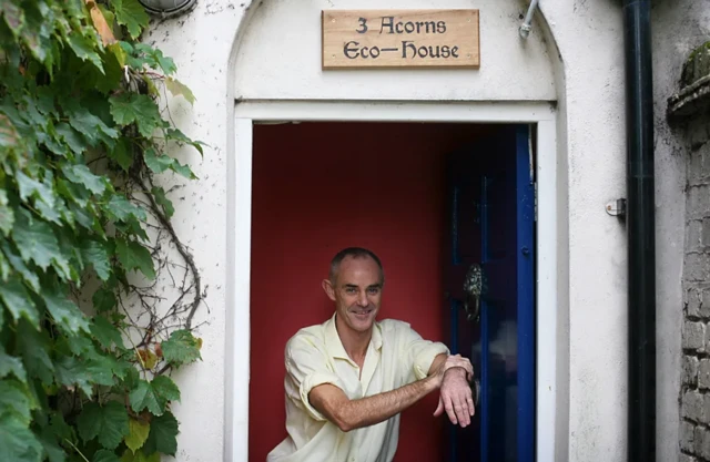 Donnachadh McCarthy devant une maison