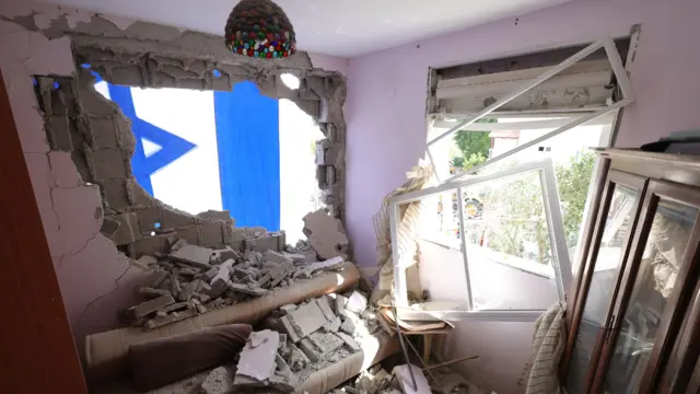 صورة تظهر أثاث مدمر وزجاج نوافذ مكسوراً داخل منزل بعد هجوم صاروخي على حي سكني في كريات بياليك، شمال إسرائيل.