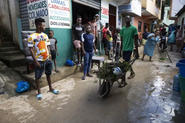 La gente limpia sus casas después del desastre causado por las inundaciones. 