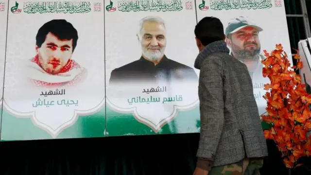 یک مرد یمنی در مقابل تصاویر بها ابوعطا، رهبر سابق جنبش جهاد اسلامی فلسطین، قاسم سلیمانی، فرمانده پیشین نیروی قدس سپاه پاسداران، و یحیی عیاش، فرمانده سابق گردان‌های عزالدین قسام، در نمایشگاه «هفته شهدا» در شهر صنعا - ۷ دسامبر ۲۰۲۳