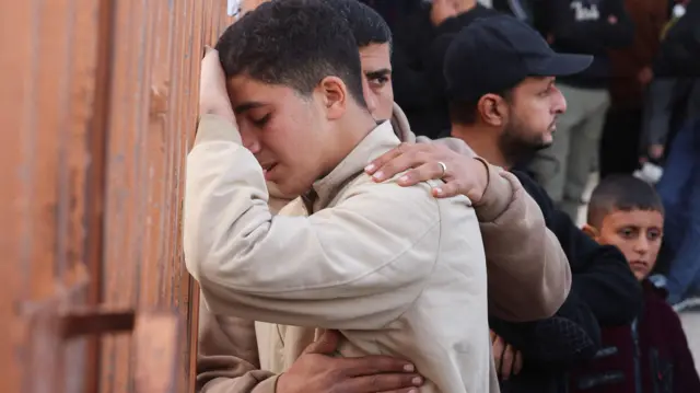 شاب يرتكز على جدار ويبكي خلال تشييع القتلى في القصف الإسرائيلي 15 فبراير/شباط 2026