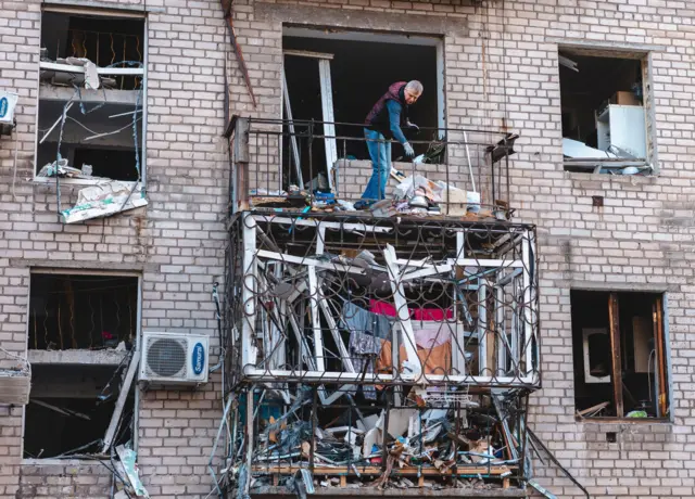 صورة لشخص يتفقد حطاماً داخل مبنى سكني تعرض لضربة روسية في منطقة دنيبرو في أوكرانيا.