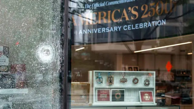 店舗の窓ガラスにひびが入っている。ガラスの向こう側にはホワイトハウス土産のようなものが見える