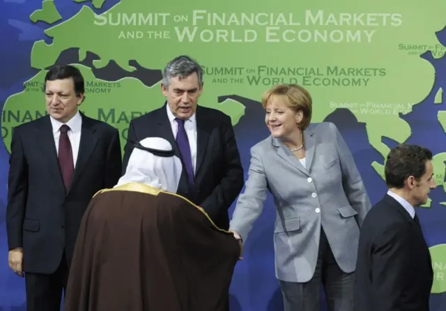 A chanceler alemã Angela Merkel (2ª à direita) cumprimenta o rei saudita Abdullah Al Saud enquanto posam para a foto oficial ao lado de (da esquerda para a direita) o presidente da Comissão Europeia, José Manuel Barroso, o primeiro-ministro britânico Gordon Brown e o presidente francês Nicolas Sarkozy, na abertura da Cúpula do G20 em 15 de novembro de 2008, em Washington.
