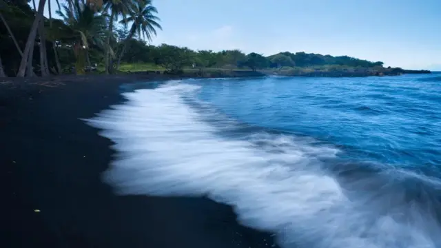 Profesor Poremba tertarik pada suara denting kaca ombak di pantai vulkanik.
