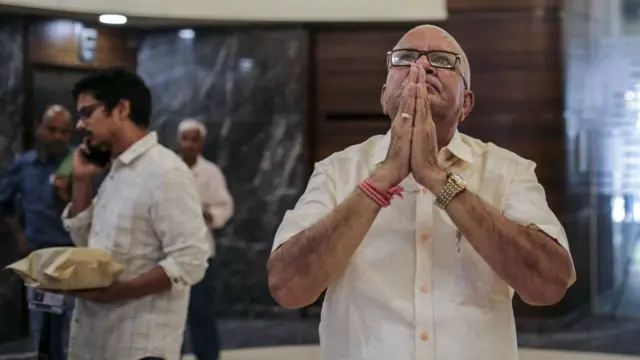 हात जोडलेला एक वृद्ध माणूस 